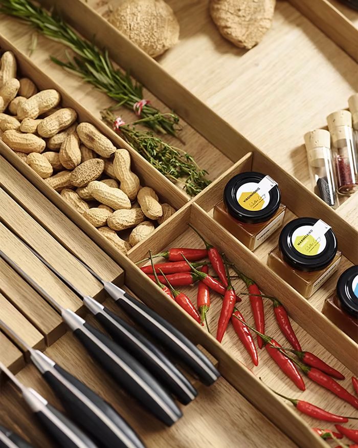 The image shows a carefully organized professional wooden Kessebohmer MosaiQ knife holder, with natural spices and cooking tools neatly arranged next to the knives. The holder highlights elegance and functionality, adding natural aesthetics and organization to the kitchen.