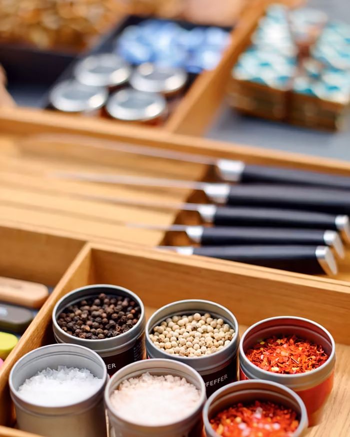 This image showcases the meticulous organization of a modern kitchen space using the Kessebohmer MosaiQ knife holder. The spices are neatly arranged in special containers within a wooden drawer, emphasizing the harmony and functionality that German design offers, while the knives are organized and easily accessible.