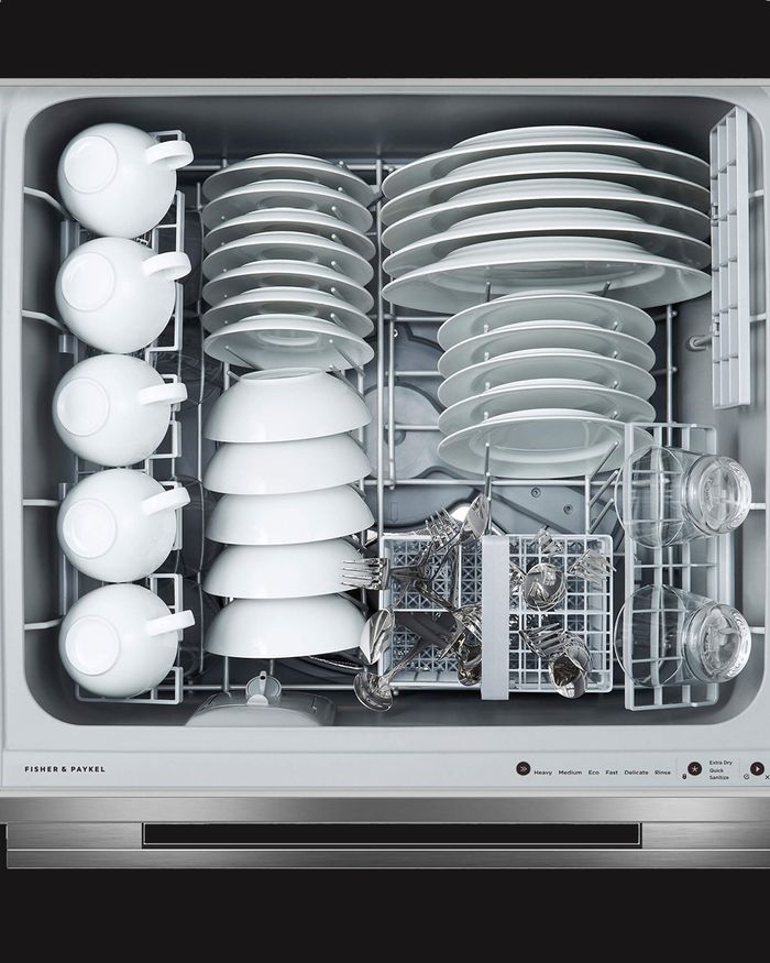 Interior view of the Mebel Arts dishwasher drawer, loaded with white plates and glasses for effective cleaning.