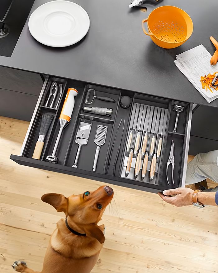 Practical kitchen drawer organizer by Mebel Arts, featuring BLUM's Ambia Line knife holder, filled with knives and utensils.