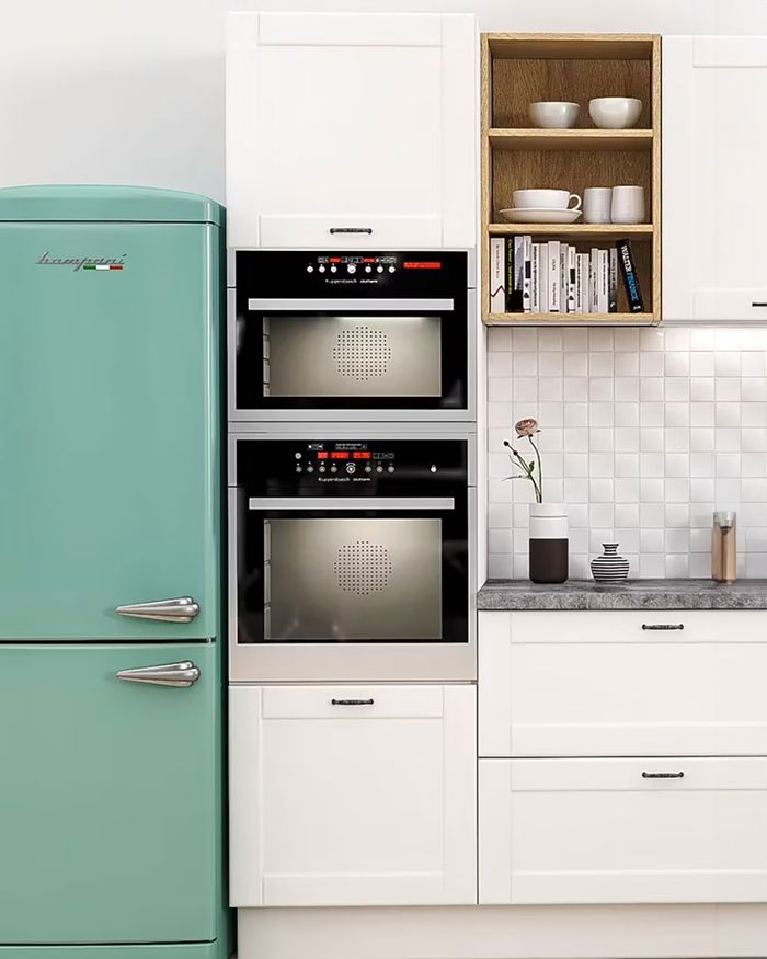 Elegant Mebel Arts design with double ovens and a retro refrigerator in pastel green color.