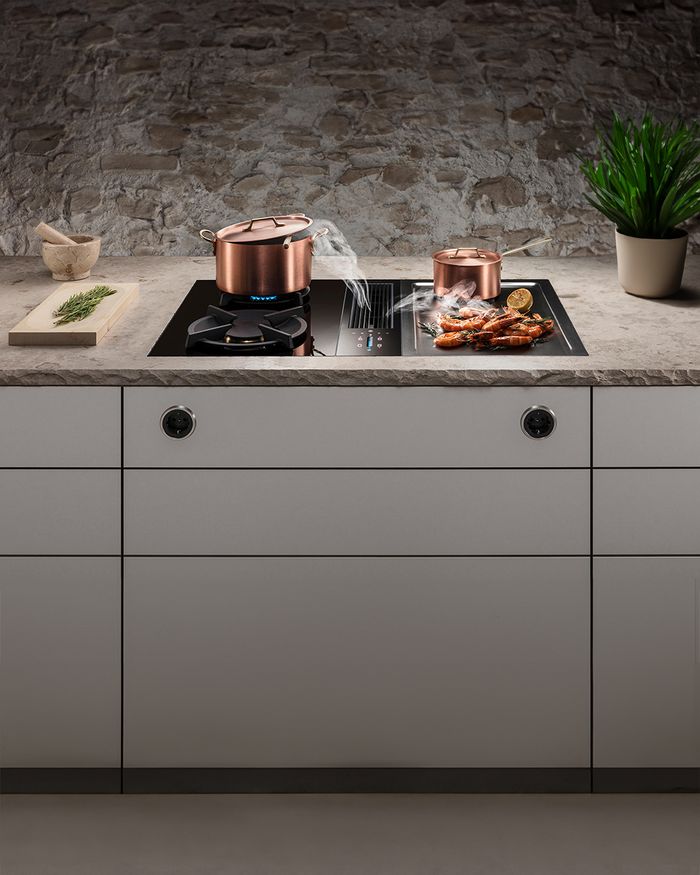 Copper cookware on a BORA Classic hob, placed in an elegant Mebel Arts kitchen with a natural texture.