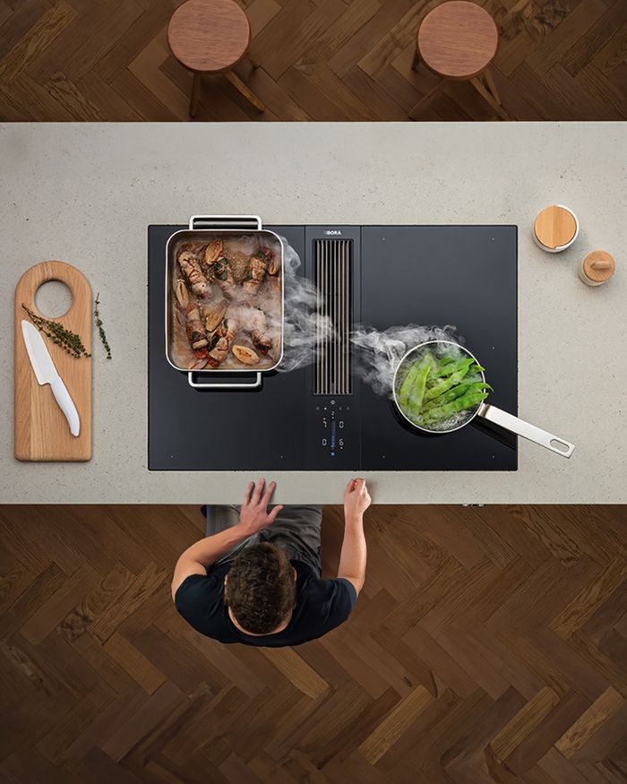 Préparation d'un repas savoureux sur une plaque de cuisson BORA Classic, faisant partie de la cuisine contemporaine Mebel Arts.