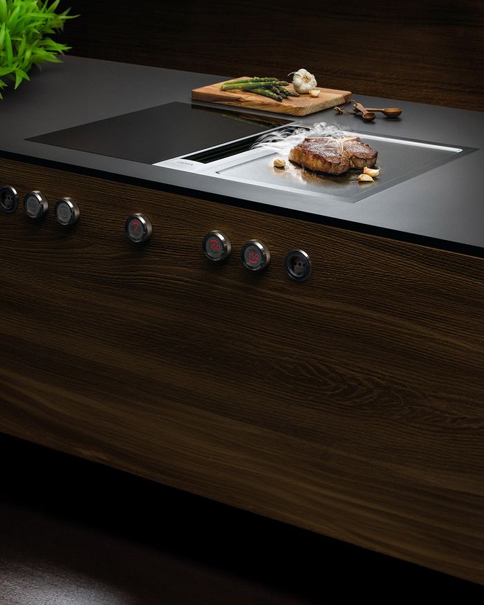 Gourmet cooking on the BORA Professional 3.0 hob, integrated into a wooden kitchen by Mebel Arts.