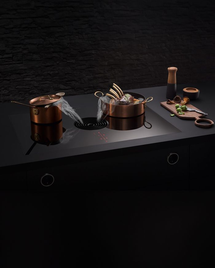 Exquisite copper pot on BORA X PURE extraction cooktop, a symbol of elegance in Mebel Arts kitchens.