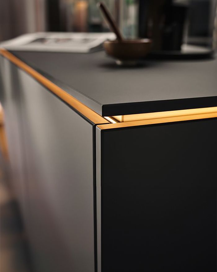 Elegant REHAU kitchen countertop with illuminated Gola handle for a modern and functional aesthetic.