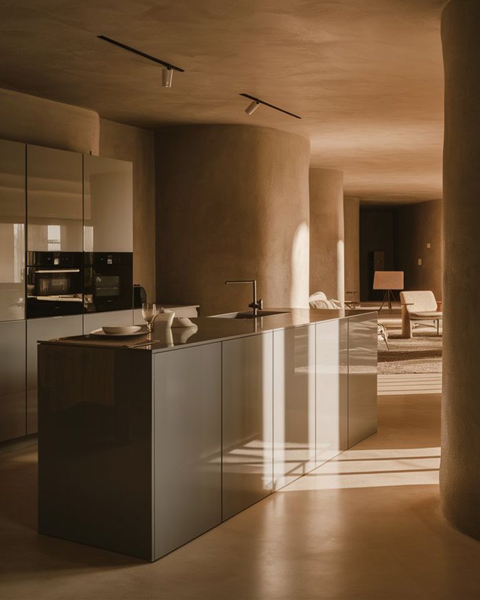 Kitchen with a glossy island and cabinets in warm earthy gray tones. The space is bright with curved walls and modern furniture. Ideal kitchen furniture.