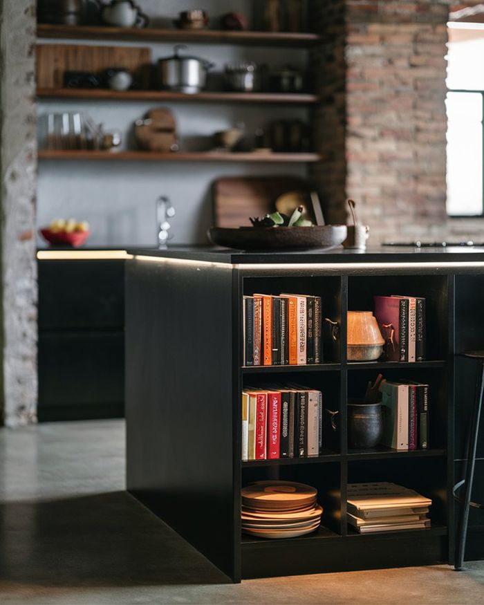 Modern kitchens with open shelves and an integrated bookshelf. Warm, industrial design with exposed bricks and natural materials. Mebel Arts.