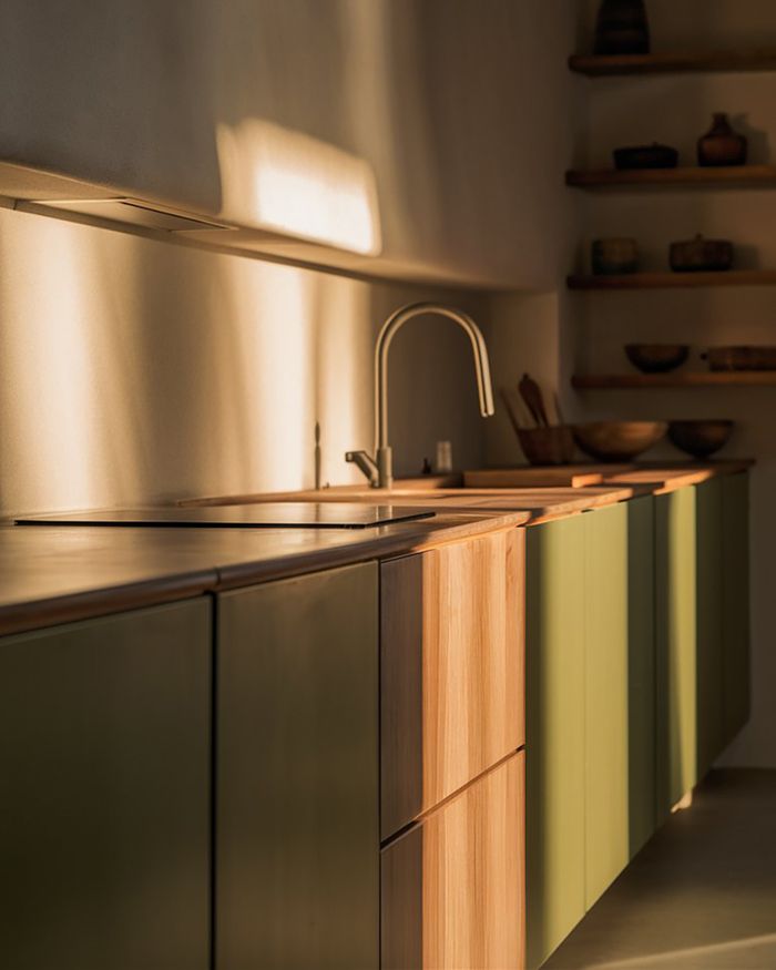 Kitchen furniture in Athens with green cabinets and wooden details. Minimalist design with warm lighting that adds elegance to the space by Mebel Arts.