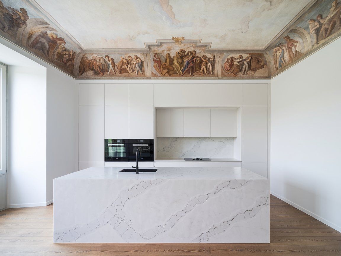 A modern kitchen with a marble island and an impressive ceiling featuring murals a design that highlights the philosophy behind the best kitchens.