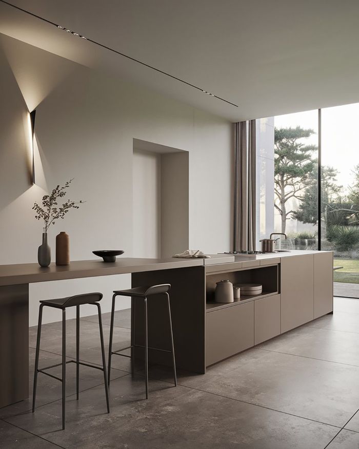 Cuisine moderne avec îlot, table intégrée et design minimaliste, éclairée par la lumière naturelle.